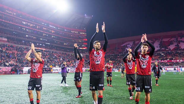 Jugadores de Xolos aplauden después de ganar partido.